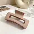 Gros plan d'une pince à cheveux carrée beige mat sur un fond de bureau blanc épuré - Rose Lotus Mat