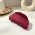 Detail view of the matte burgundy semi-circular hair claw clip on a minimalist background - Matte Wine Red