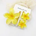 Detail view of three vibrant yellow frangipani flower hair clips on a jewelry card. - 3-Piece Set (1 Large 2 Small) / Yellow & Yellow