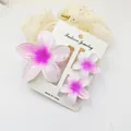 Set of three pink plumeria flower hair claw clips displayed on a white jewelry card - 3-Piece Set (1 Large 2 Small) / White And Pink
