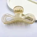 Detailed macro view of minimalist jelly champagne hair claw clip with golden spring. - Jelly Beige