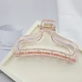 Detail view of a minimalist transparent pink hair claw clip placed on a white tray - Transparent Hair Claw / Peach Pink