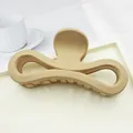 Detail view of large matte beige hair claw clip with elegant figure-eight bow design - Khaki