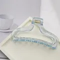 Close-up view of a minimalist light blue transparent acrylic hair claw clip on tray - Semi-Transparent Hair Claw / Light Blue