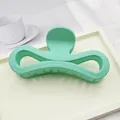 Close-up view of a large matte mint green hair claw clip placed on a white display tray - Emerald Green