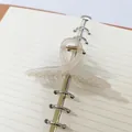 Detailed view of an elegant cream ribbon-style hair claw clip placed on a paper notebook. - Ribbon Style (16) / 11cm / Transparent White