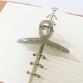 Detail view of a grey translucent ribbon-style hair claw clip placed on a spiral notebook - Ribbon Style (16) / 11cm / Transparent Grey