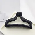 Close-up of a minimalist large black hair claw clip on a chic white display tray - Solid Black