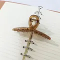 Detail view of a brown transparent ribbon hair claw clip on a notebook background. - Ribbon Style (16) / 11cm / Transparent Brown
