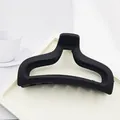 Macro view of a minimalist matte black shark hair claw clip on a clean white tray - Matte Black