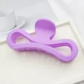 Detailed view of a large matte purple bow-shaped hair claw clip on a white tray - Lavender