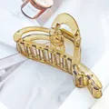 Elegante bernsteinfarbene, herzförmige Haarklammer aus Acryl auf einem Magazin im Detail. - Metallic Braun