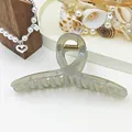 Close-up of a large translucent grey jelly hair claw clip with a ribbon twist design - Gray