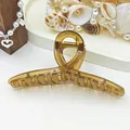 Close-up of a large amber jelly ribbon hair claw clip with a glossy finish - Coffee