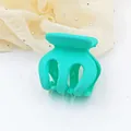 Macro detail showing the matte finish of a small turquoise hair claw clip for side fringe. - Emerald Green