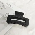 Vue détaillée d'une pince à cheveux noire mate avec une élégante texture matelassée - Carré losange / Noir mat