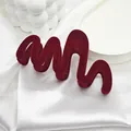 Elegant macro view of a large wavy deep red velvet hair claw clip on white silk fabric - 11 Wave Style / Burgundy