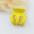 Detailed macro view of a vibrant yellow matte hair claw clip for hair styling - Yellow