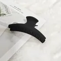 Gros plan sur une pince à cheveux noire mate de taille moyenne au design en croissant - Style Griffe Droite / Noir mat