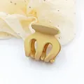 Close-up detail of a small beige matte finish hair claw clip for side styling. - Beige