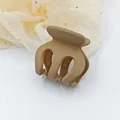Detailed view of a small matte brown plastic hair claw clip for elegant hair styling. - Brown