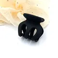 Close-up view of a small matte black hair claw clip featuring a durable multi-prong design - Black