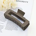 Detail view of a large matte mocha brown square hair claw clip on a stylish background. - Dark Coffee