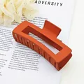 Detailed shot of a large matte orange square hair claw clip featuring a modern design - Orange
