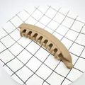 Matte light brown banana hair clip for thick hair shown on a grid pattern plate - Matte Khaki