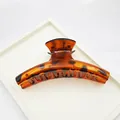 Close-up of a large tortoiseshell hair claw clip with a glossy finish on a white tray - Round Bar Claw Style / 9cm / Red Leopard