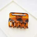 Detail shot of a large leopard print tortoiseshell hair claw clip on white display tray - Small Claw Style / 5.50cm / Red Leopard