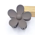 Close-up showing the matte texture and five-petal design of the grey flower hair claw clip - Dark Coffee