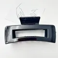 Detailed macro view of a large glossy black rectangular hair claw clip for hair styling - Black