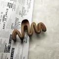 Detailed view of a matte brown wavy hair claw clip on a decorative paper background. - Wave / 11cm / Medium Coffee