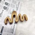Detailed macro view of the matte wave-shaped hair claw clip on a soft background. - Wave / 11cm / Khaki