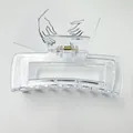 Macro view of a large clear rectangular hair claw clip with golden metal spring - Clear