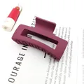 Side view of a matte burgundy square hair claw clip resting on a white paper page - Burgundy / 8.5cm