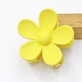 Detailed close-up showing the matte frosted texture of this yellow five-petal flower hair claw - Yellow