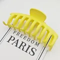 Primer plano macro de una pinza para el pelo de tiburón amarillo mate sobre tarjeta blanca - Amarillo