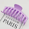 Primer plano detallado de una pinza grande para el pelo morado mate sobre tarjeta blanca - Violeta