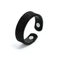 Detailed view of the black magnetic therapy ring with embossed patterns and dual magnets. - Black