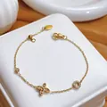 Detail view of an elegant gold bracelet with sparkling flower and circle charms on box. - 554 Bubble Ring Crystal Flower Style