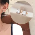 Macro detail of elegant rose gold four-prong square stud earrings with faceted crystals - Stud Earrings / Rose Gold