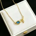 Detailed macro view of elegant gold tulip necklace with blue crystal pendant in a box - Blue
