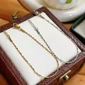Close-up of gold and silver titanium steel fine necklaces on a jewelry box - Gold Bracelet (5517) / Gold
