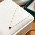 Elegant gold stainless steel necklace featuring a petite red heart-shaped birthstone pendant. - January Garnet Red