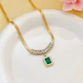 Close-up of gold blade chain necklace with green square zircon pendant detail - Necklace (8439) / Gold