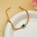 Close-up of gold blade chain bracelet featuring a square green zircon centerpiece. - Bracelet (5360) / Gold