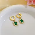 Macro detail of gold plated earrings featuring emerald-cut green zircon with crystal halo - Earrings (7662) / Gold