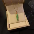 Detailed view of a green bamboo pendant necklace with butterfly crystal accents. - Green Bamboo Necklace (Lip Chain) / Green
